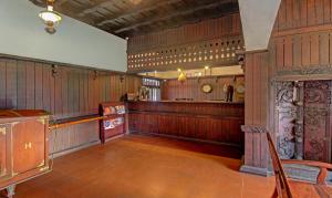AlleppeyTreebo Tryst Travancore Palace Cherthala的大型客房,设有木镶板和酒吧