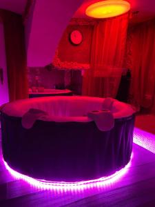 Gnesau拉格维特旅馆的一间设有圆形浴缸的客房,配有紫色灯