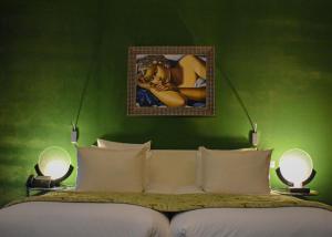卡萨布兰卡Hôtel particulier Le DOGE - Relais & Châteaux的一间卧室设有绿墙、一张床和两盏灯。