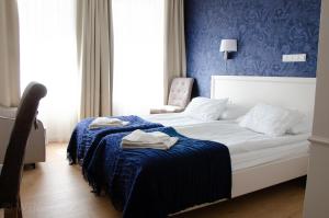 索波特鲍尔蒂克别墅酒店 的一间卧室配有一张蓝色墙壁的床
