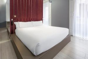 马德里B&B HOTEL Madrid Centro Fuencarral 52的红色床头板的房间里一张白色的床