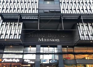 马尼拉Malate Bayview Mansion city view的一座建筑,上面标有读集市大厦的标志