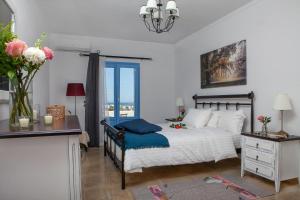 安坡里奥圣托里尼Sunrise Apartment Santorini的一间卧室配有一张床、一张书桌和一个窗户。