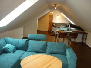 巴斯托夫Pension Dachgeschosswohnung的客厅配有蓝色的沙发和桌子