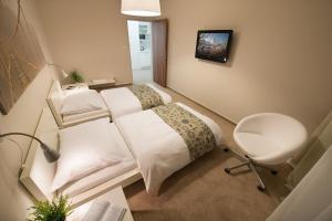 布拉格科特布斯酒店的一间卧室配有一张床、一张桌子和一把椅子