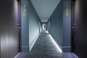 欧阿提兹B&B HOTEL Donostia Aeropuerto的一条空的走廊,有蓝色的墙壁和长长的走廊