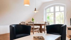 博恩Haus Alte Bäckerei - Boddenblick的一间带桌椅和窗户的用餐室