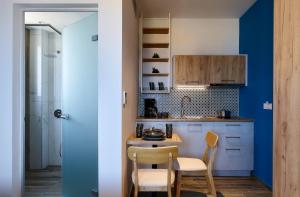 帕诺尔莫斯雷斯蒙Theasea Stylish Residences的厨房拥有蓝色的墙壁,配有桌椅