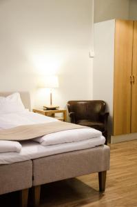 哥德堡香草酒店的一间卧室配有一张床和一张皮椅