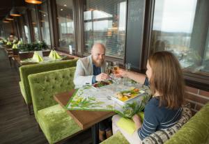 KarjalohjaLohja Spa & Resort的坐在餐厅桌子上的男女
