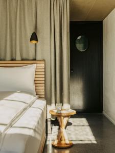 巴塞尔Boutique & Design Hotel Volkshaus Basel的卧室配有一张床和一张桌子,位于门边