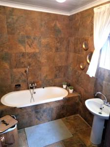 LichtenburgEdenville Guesthouse的带浴缸和盥洗盆的浴室