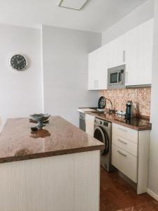 多列毛利诺斯Apartamentos Calma Rentals的厨房配有白色橱柜和大理石台面