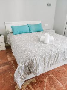 多列毛利诺斯Apartamentos Calma Rentals的一张白色的床,上面有蓝色枕头
