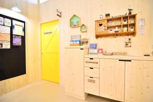 马公澎湖紙飛機民宿Paper Jet B&B的一间设有黄色门和柜台的房间