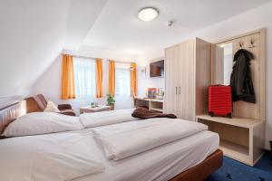 罗滕堡陶本罗腾堡拉普酒店的一间卧室配有两张床和红色的行李箱