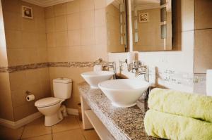 格罗斯岛Bay Gardens Beach Resort & Spa的浴室设有2个水槽、卫生间和镜子。