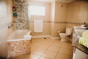 格罗斯岛Bay Gardens Beach Resort & Spa的带浴缸、卫生间和盥洗盆的浴室