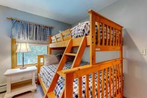 贝塞尔Sunday River Sunny Chalet的一间卧室配有带梯子的双层床
