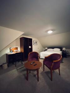 波茨莱德Clifton House Brighton的酒店客房配有一张床、两把椅子和一张桌子