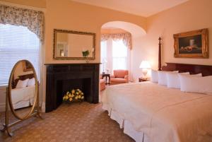 米德尔堡米德尔堡酒店的一间卧室配有一张床、一个壁炉和一个镜子