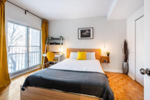 蒙特利尔Les appartements HOMA的一间卧室设有一张床和一个大窗户