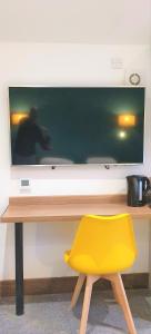 史云顿巴斯路公寓的一张桌子前面的黄色椅子,电视机