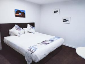 阿波罗湾ODYSSEY APOLLO BAY的一间卧室配有带白色床单和枕头的床。