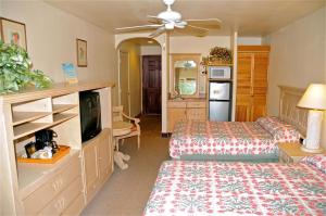 Waimea西考艾岛酒店的一间卧室配有一张床,并在一间客房内配有电视。