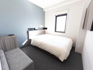 能美市Super Hotel Ishikawa Nomineagari Smart Inter的卧室配有白色的床和窗户。