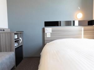 能美市Super Hotel Ishikawa Nomineagari Smart Inter的一间酒店客房,配有一张床和一台电视