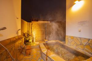 由布市Yufuin Matsuri-an Nagomiya的一间带浴缸和蒸汽淋浴的浴室