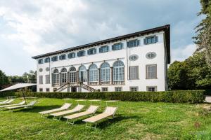 卢卡Villa Guinigi Dimora di Epoca Exclusive Residence & Pool的一组躺椅,位于大楼前