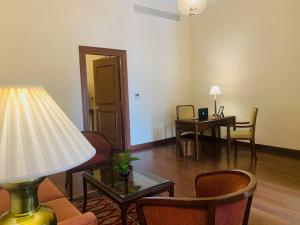 新德里新德里梅顿酒店的客厅配有台灯和桌椅