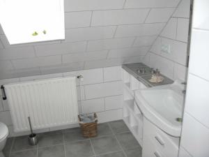EggebekFerienhaus Frey的白色的浴室设有水槽和卫生间。