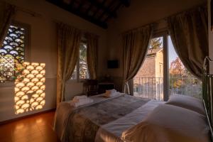 Santa VenerandaIl Pignocco Country House的一间卧室配有床和带窗帘的窗户
