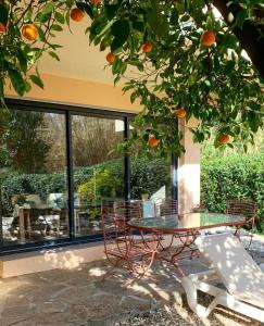 勒拉旺杜Les Sarments的橘子树下的桌子和椅子
