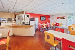 塞尔吉瑟伊圣克利斯朵夫普瑞米尔经典酒店的餐厅拥有红色的墙壁和桌椅