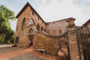 圣罗科阿费力Borgo San Lorenzo a Linari的一座古老的砖砌建筑,前面设有长凳