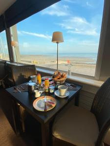 基贝维尔Hotel De La Plage的一张带食物的桌子,享有海滩美景