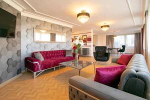 伊斯坦布尔Opulent Suite Bosphorus View的客厅配有红色的沙发和桌子
