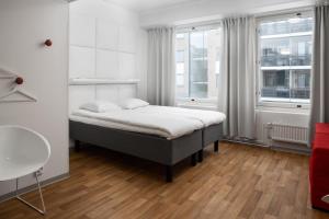 波里Omena Hotel Pori的一间卧室设有一张床和两个窗户。