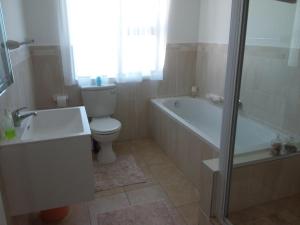 圣弗朗西斯湾Trev's Place的浴室配有卫生间、浴缸和水槽。