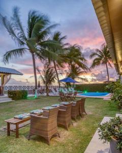 马塞约Ipioca Beach Village的一排棕榈树藤椅和游泳池