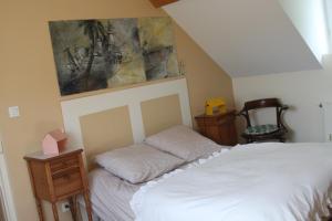 亚眠乐齐奥斯克亚眠住宿加早餐旅馆的卧室配有一张床,墙上挂有绘画作品