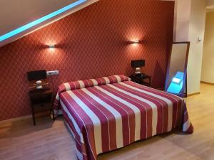 梅迪纳德里奥塞科Hospedium Hotel Vittoria Colonna的一间卧室配有带条纹毯子的床