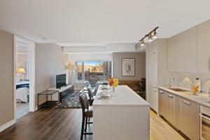 渥太华SOHO Residences Champagne的厨房以及带桌椅的起居室。
