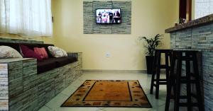 卡拉瓜塔图巴Villaggio Avansi的客厅配有沙发和墙上的电视