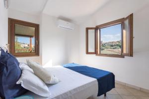 布多尼Appartamenti Tanaunella的一间卧室设有一张床和两个窗户。