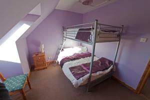 阿德西尔阿德哥瑞酒店的一间卧室配有一张带紫色墙壁的双层床
